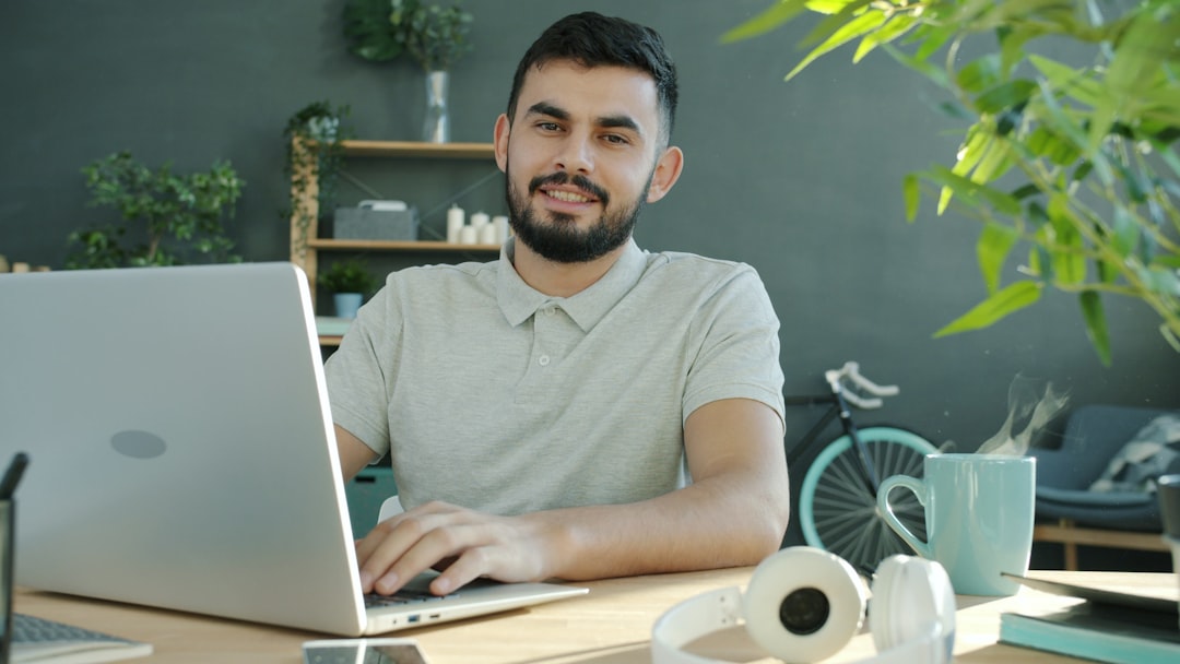 Technician working calmly on an open laptop at a home desk